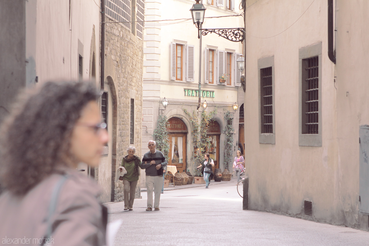 Trattoria Tranquillo Foto von A peaceful alley in Tuscany, Italy, captures everyday life near a quaint trattoria. The rustic charm of stone buildings enchants the scene.