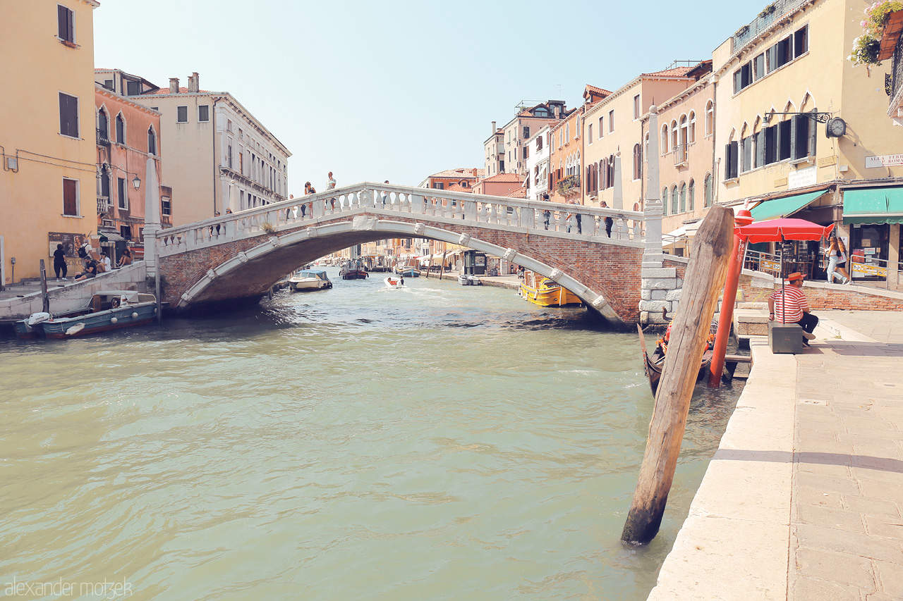 Foto von A serene canal view in Venice with a classic bridge, gondolas, and vibrant local life.