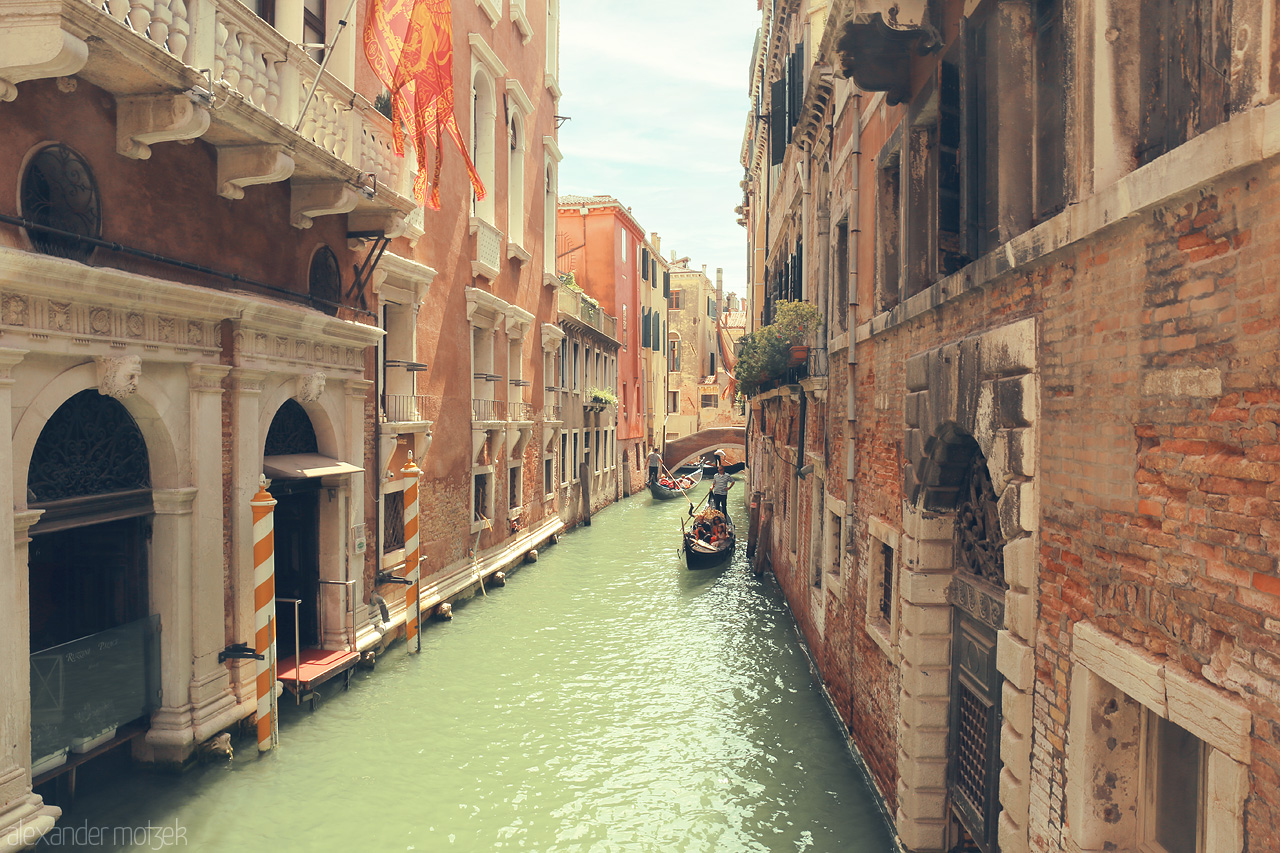 Foto von Gondolas glide through Venice's sun-drenched canals, embraced by the timeless architecture of La Serenissima.