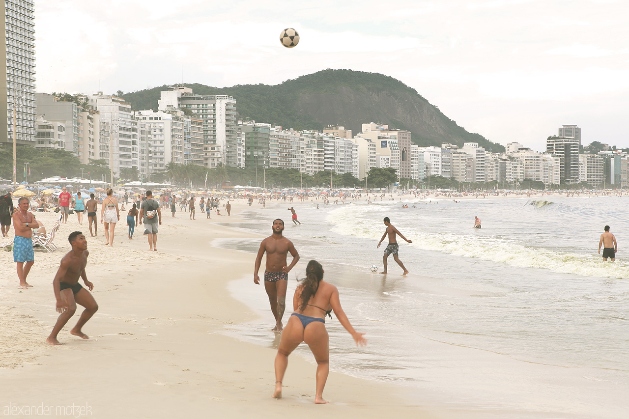 Futebol na Praia Foto von Vibrant volleyball action amid the iconic Copacabana beach, Rio's urban skyline, and rolling ocean waves.