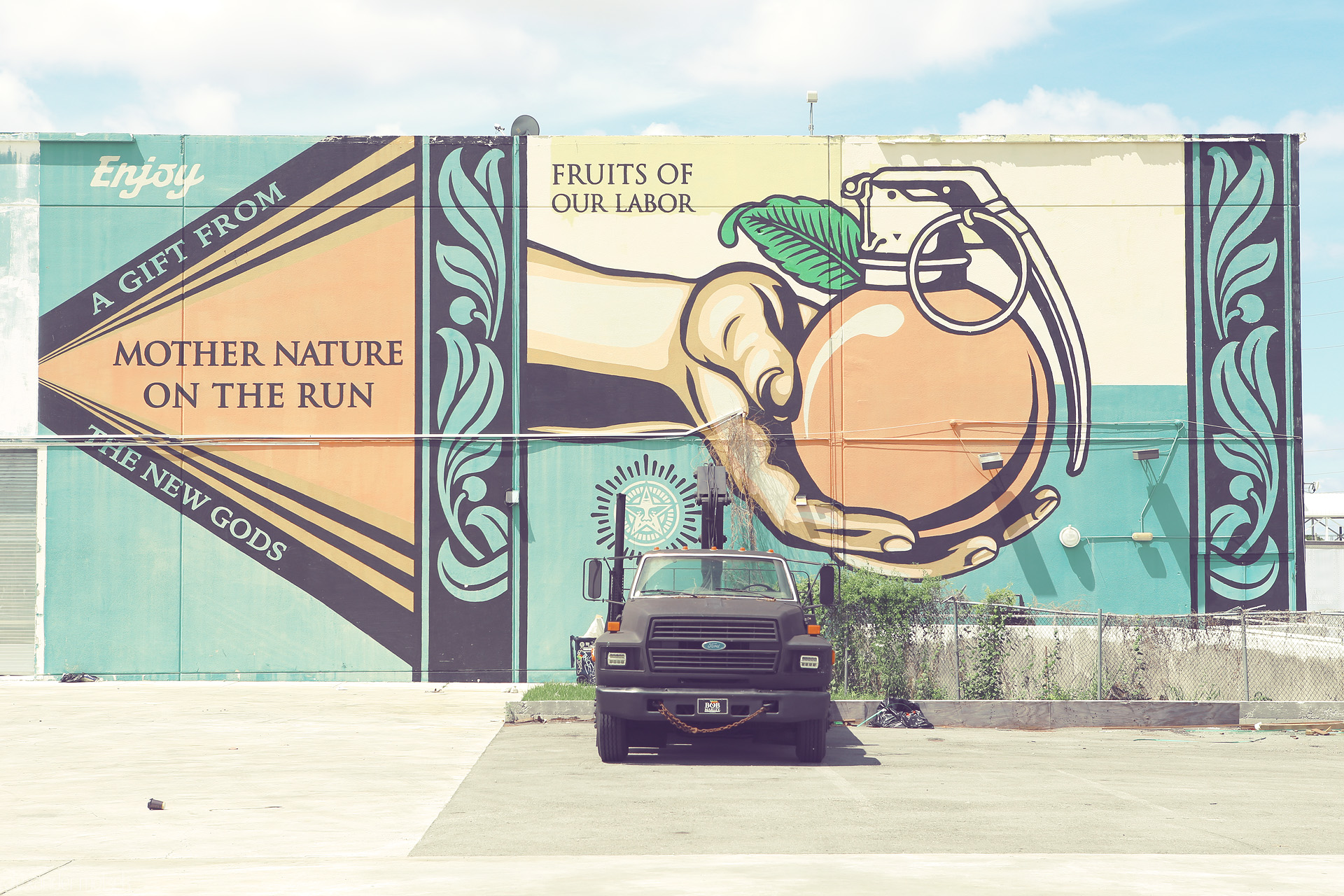 Fruity Explosion Foto von Vibrant wall mural in Miami blending a juicy orange with a grenade, symbolizing the city's explosive creativity and tropical vibe.