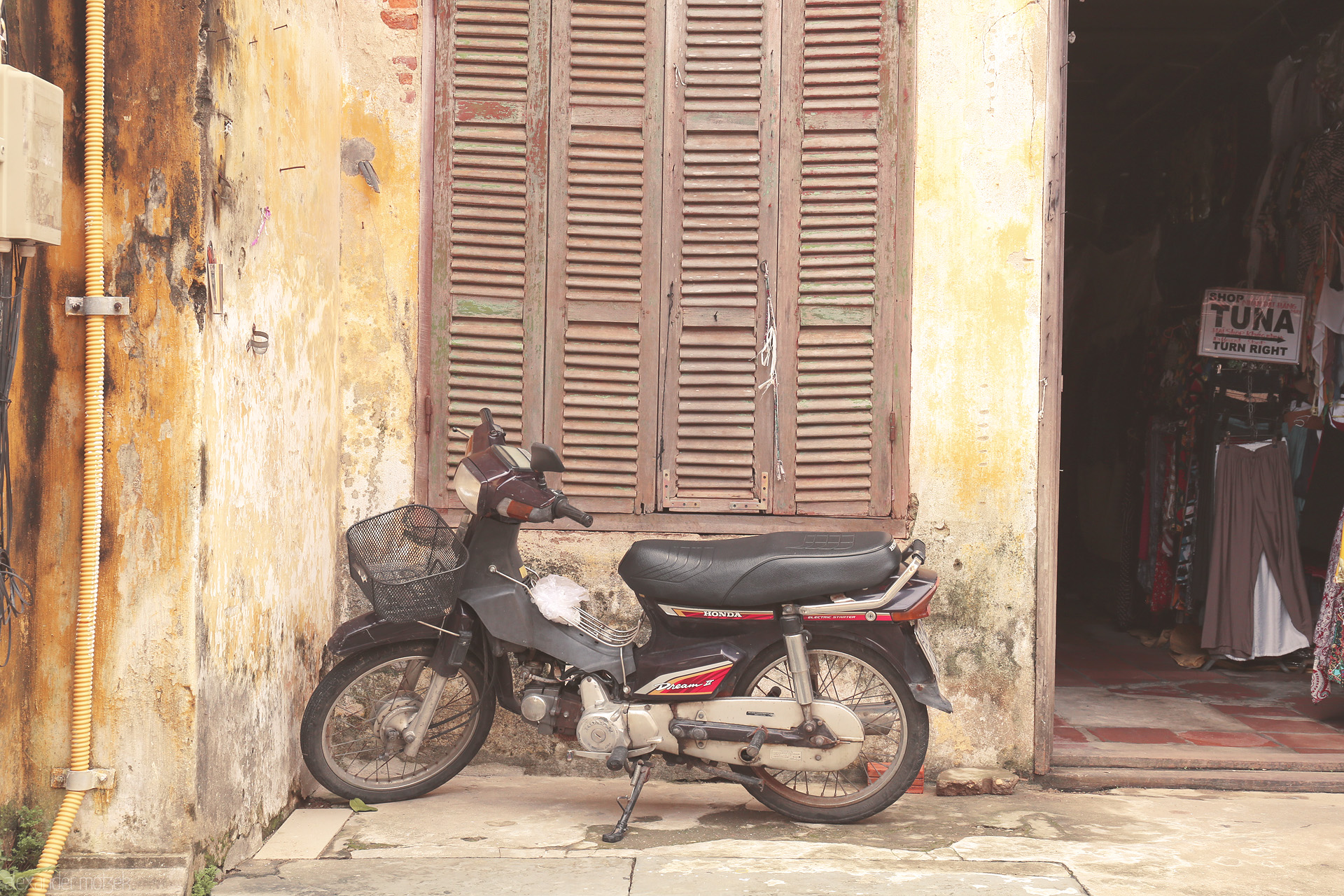 Patina Passageways Foto von A classic Honda Dream leans against sun-kissed yellow walls of old Hoi An, Vietnam, echoing stories of quiet streets and timeless charm.
