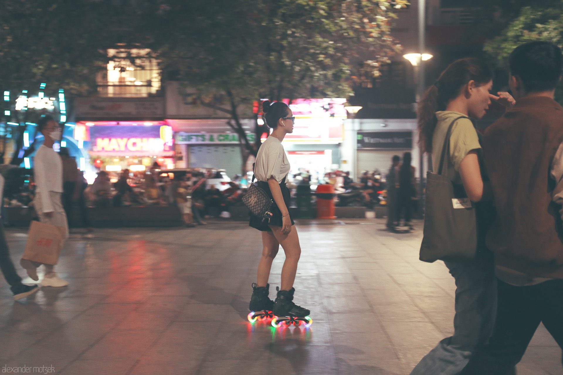 Rollin’ Nguyen Night Foto von A skater glides on neon-lit wheels through Saigon’s buzzing Nguyen Hue street, lights blurring into the electric night.