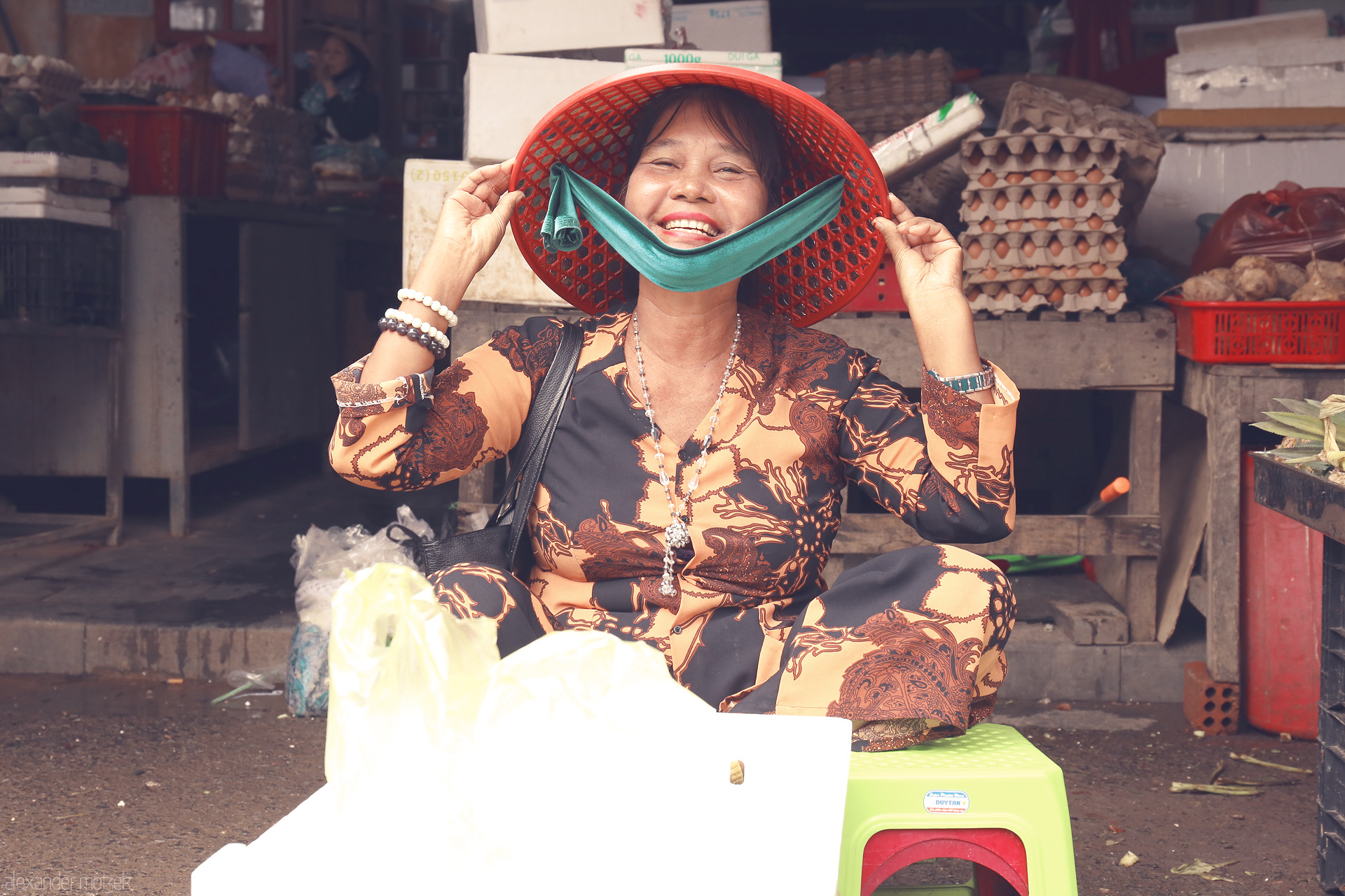 Hoi An Hạnh Phúc Foto von A vibrant smile lights up Hoi An's market, as a vendor in traditional attire shares a moment of pure Vietnamese joy and warmth.
