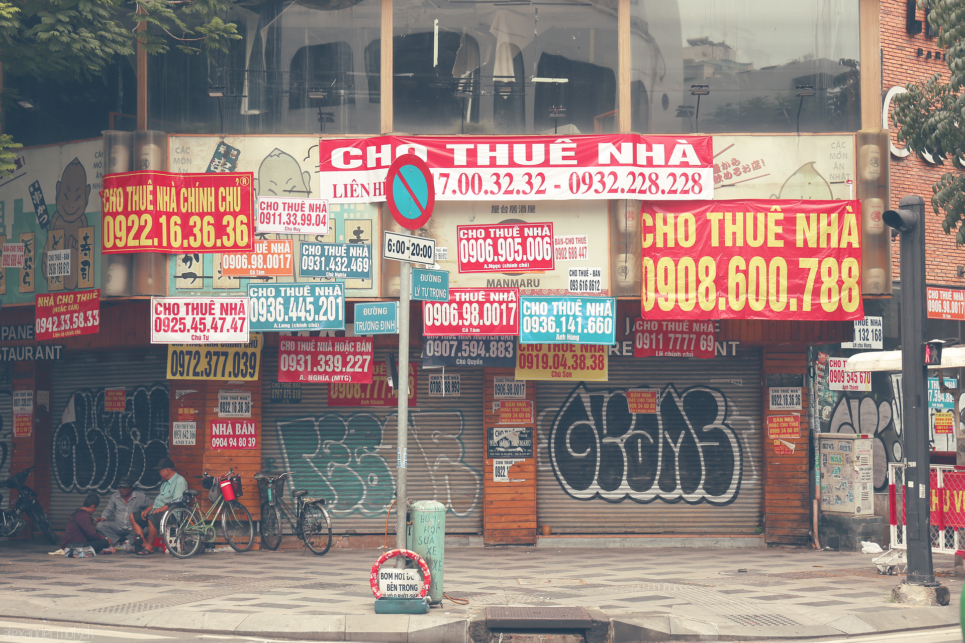 Urban Jumble, Quan Mot Foto von A vivid tangle of rental signs overshadows a shuttered storefront in the heart of Saigon, Ho Chi Minh City, Vietnam.