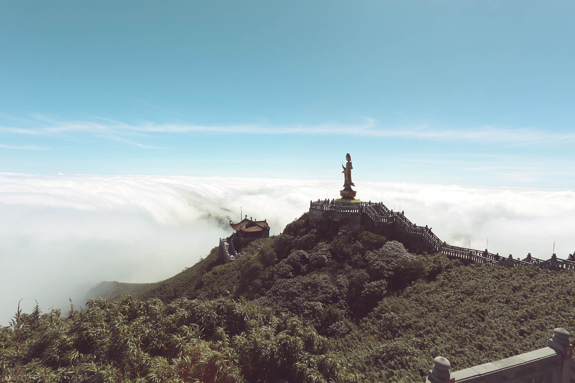 Sapa’s Heavenly Gaze Foto von Buddha watches over a sea of clouds atop Fansipan Mountain, Sapa, Vietnam; ancient serenity embraced by emerald peaks and endless sky.