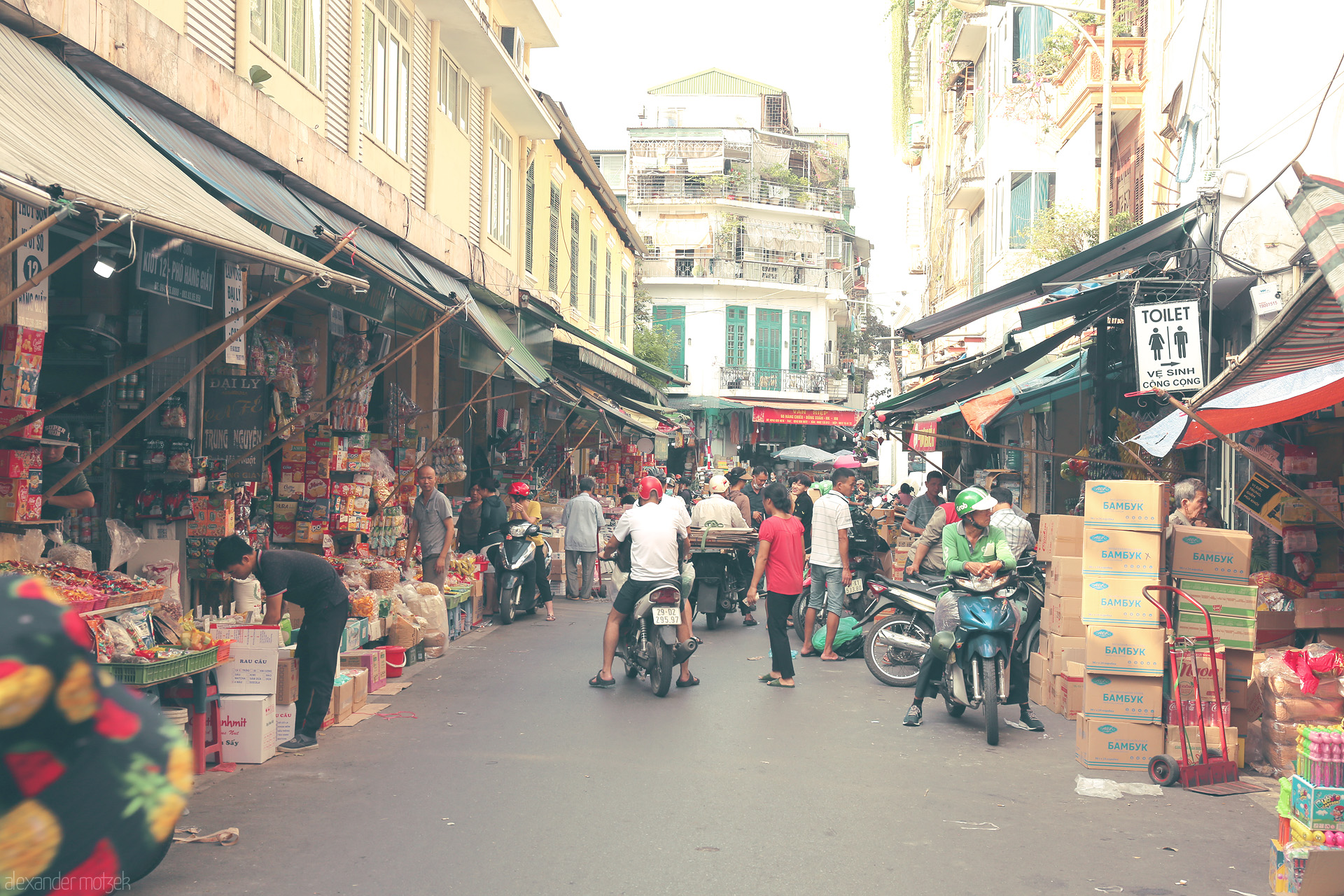Old Quarter Mosaic Foto von Bustling market life in Phuong Hàng Buom, Hanoi. Street vendors, scooters, and vibrant chaos captured in the Old Quarter.