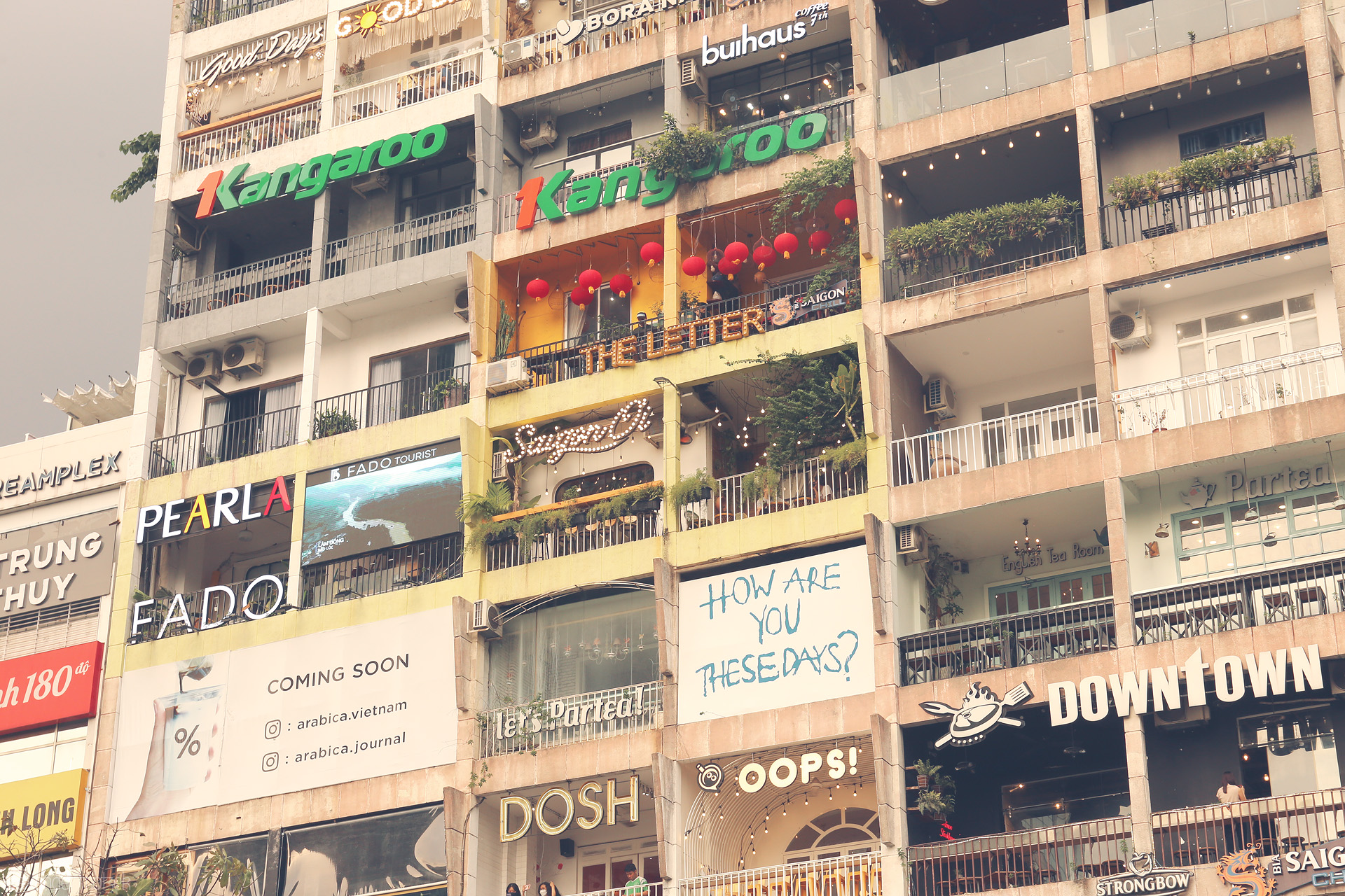 Bình Yên Balconies Foto von Eclectic cafes, neon signs & life on the iconic Saigon apartment block in downtown Ho Chi Minh City.
