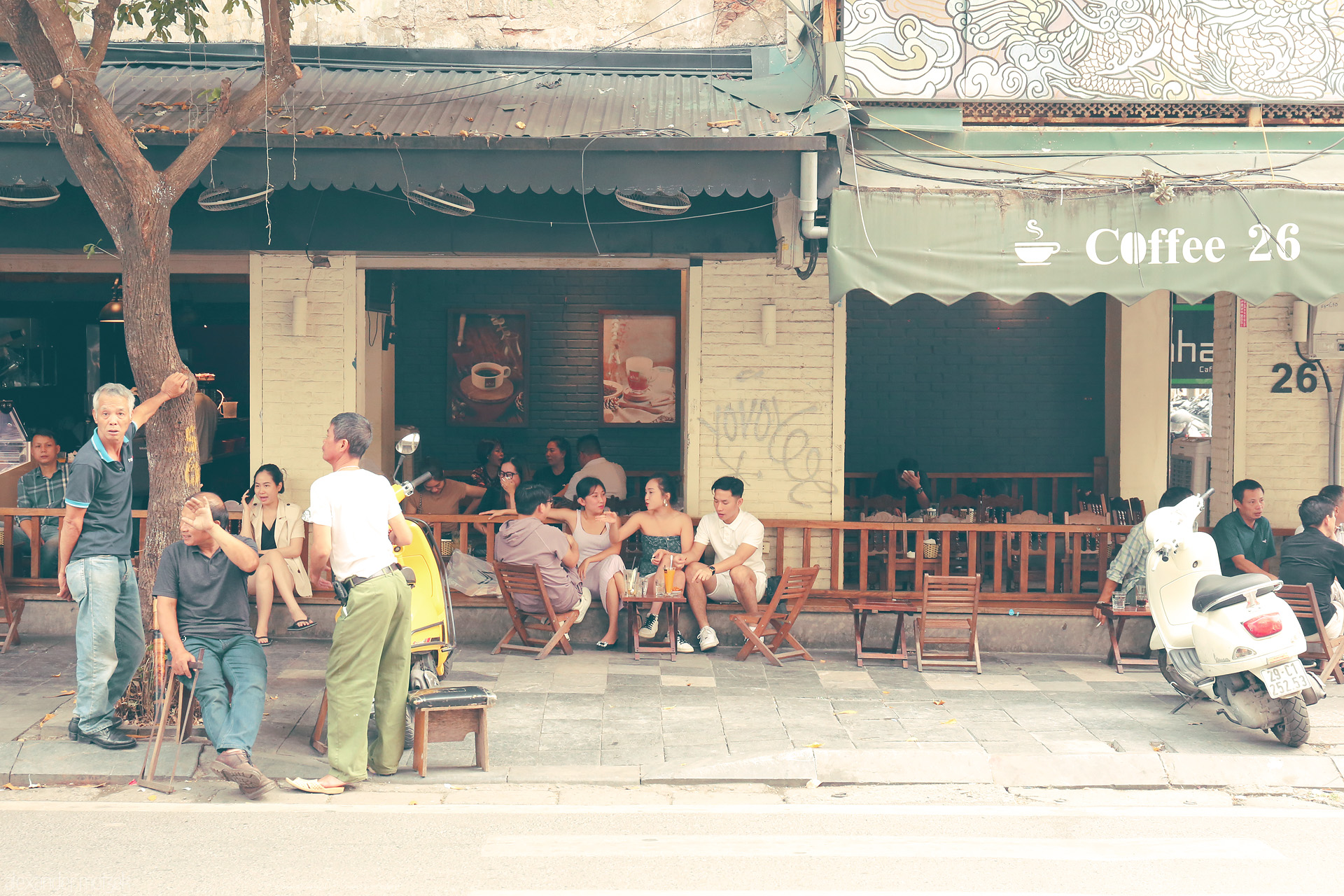 Sauntering at Coffee 26 Foto von Locals unwind at Coffee 26 in Phuong Cua Dông, Hanoi—capturing the soulful, slow charm of Old Quarter street life.