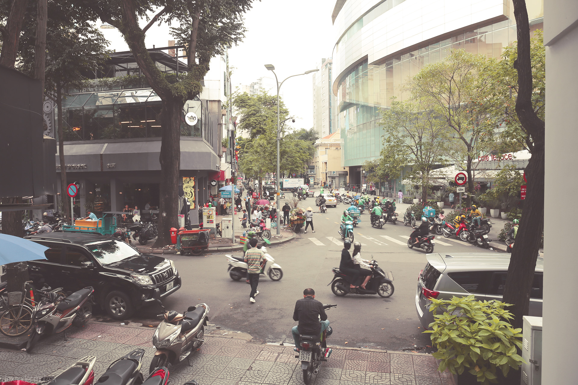 Saigon Song Dong Foto von Morning bustle in central Saigon: scooters, cafés, and city life converge under the urban trees of Ho Chi Minh City.