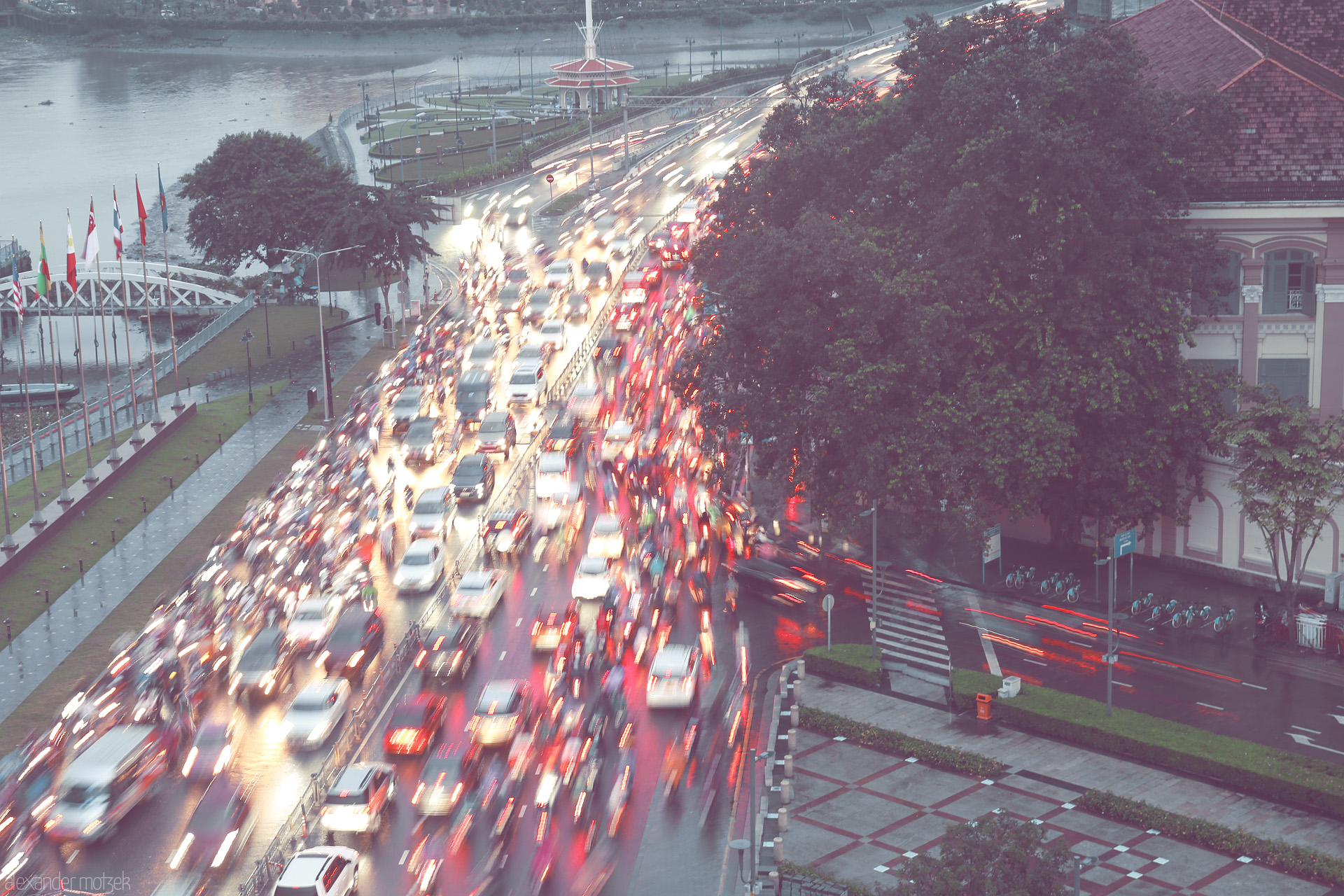 Mekong Rainlight Rush Foto von Rush hour blurs under Saigon rain—vivid lights and motorbikes race beside the river in the heart of Ho Chi Minh City.