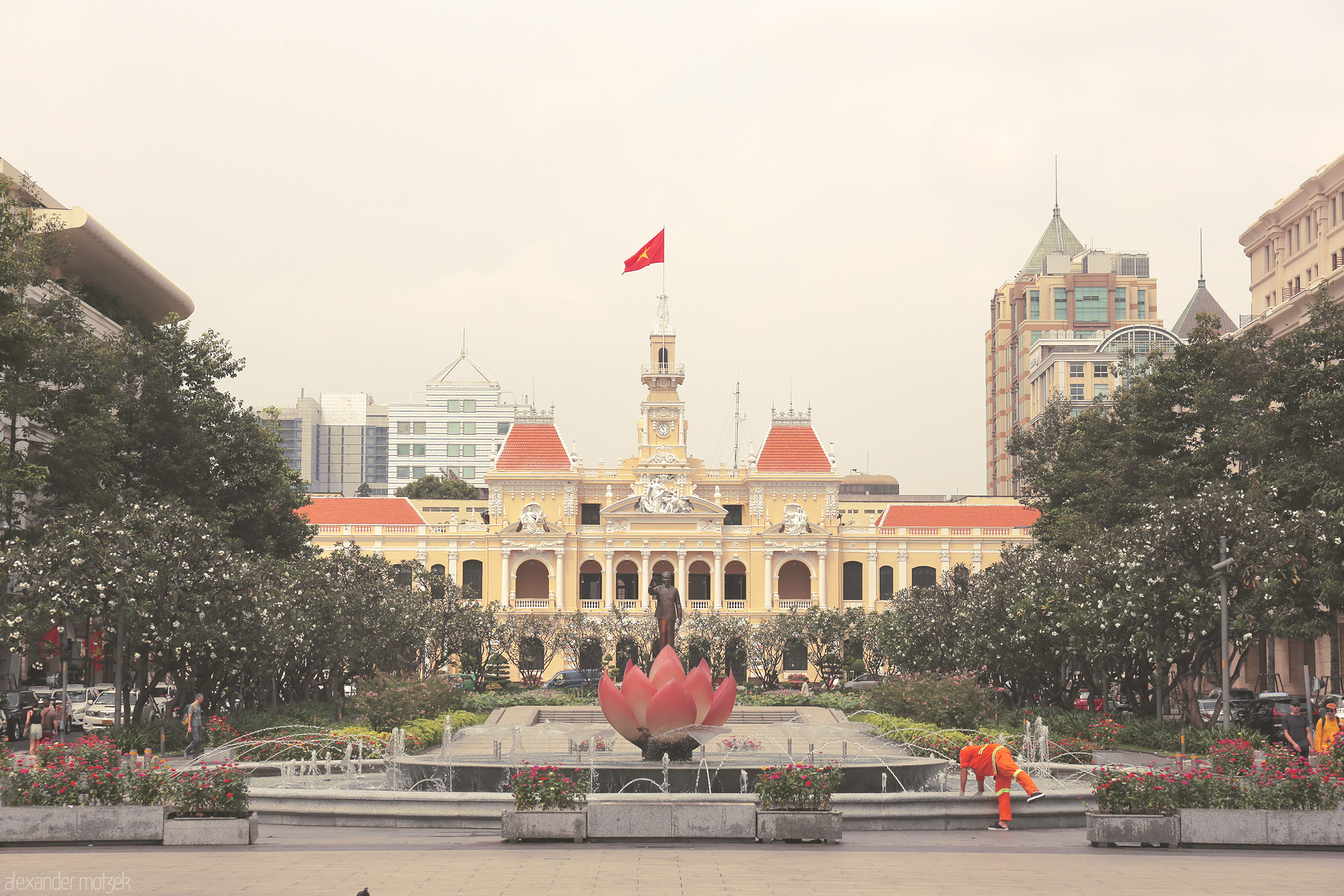 Lotus Dreams, City Streams Foto von Saigon's City Hall rises behind a blooming lotus fountain on Nguyen Hue, blending colonial charm with modern Ho Chi Minh City spirit.