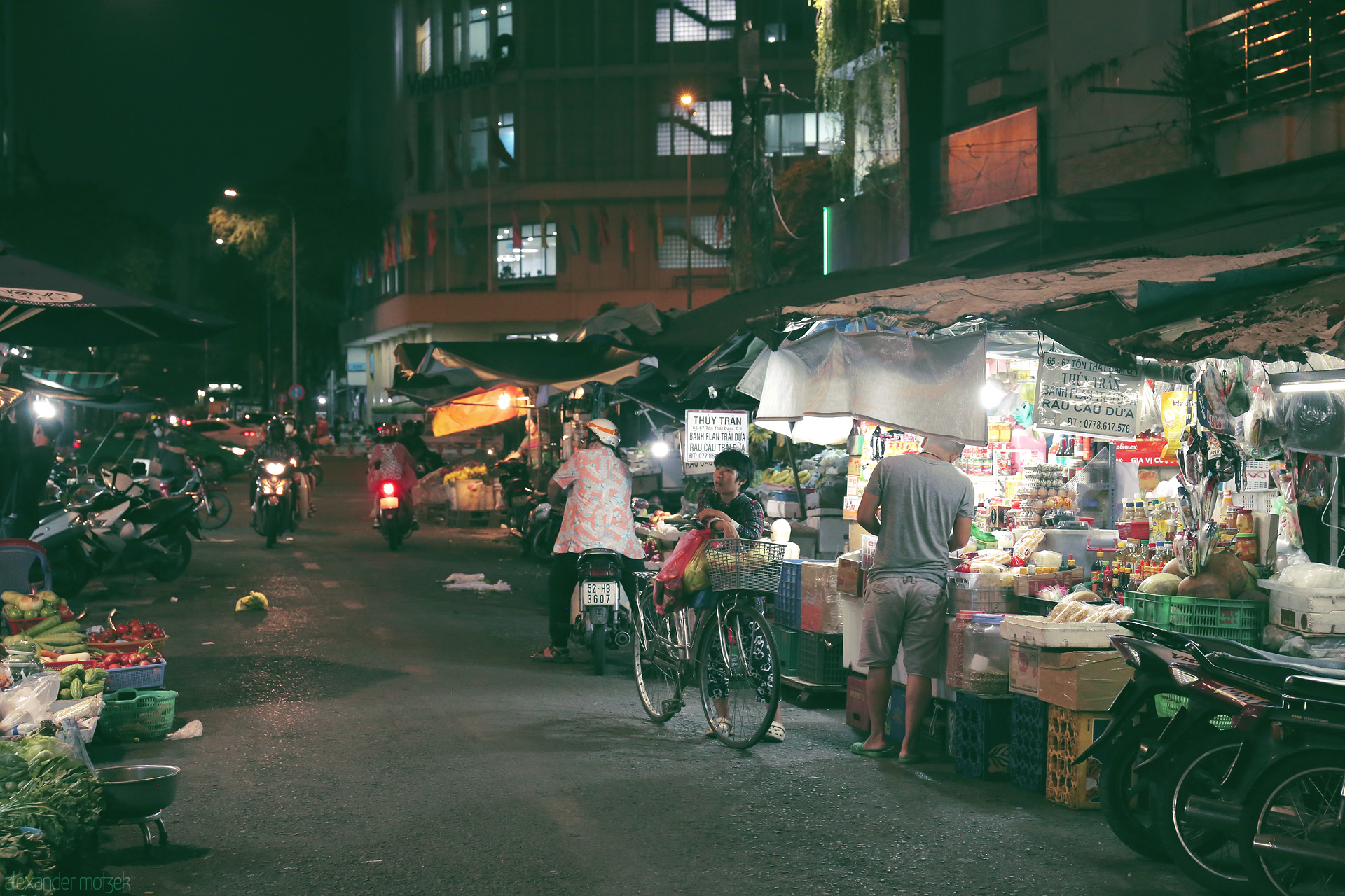 Dêm Sài Gòn Glow Foto von Saigon’s night market bustles under neon lights—vendors, scooters, and streetlife merge in the vibrant heart of Ho Chi Minh City.