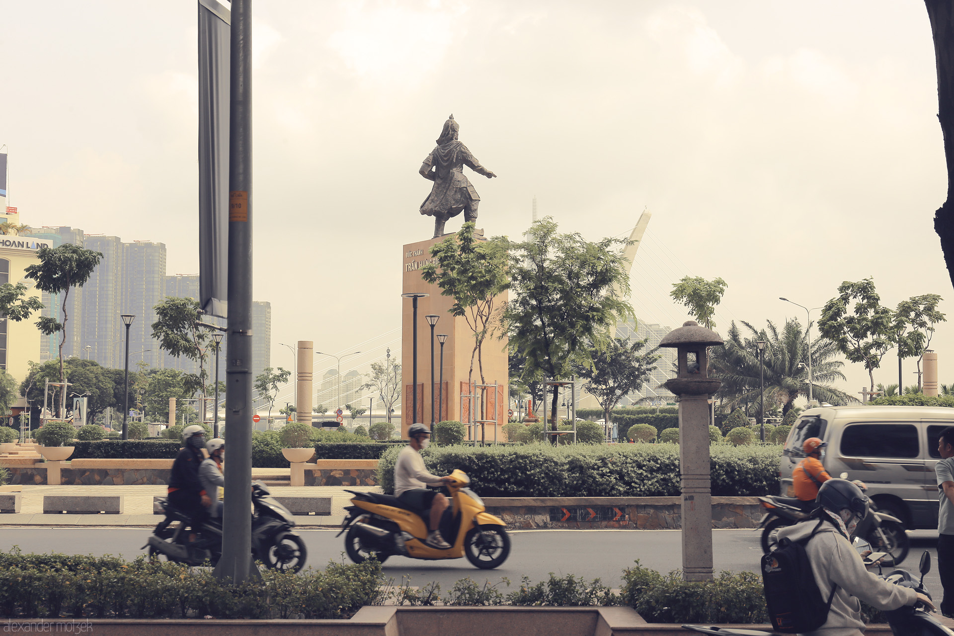 Mekong Motion Foto von Scooters whirl past the Tran Hung Dao statue in lively Ho Chi Minh City, Vietnam—a vibrant cityscape in perpetual motion.